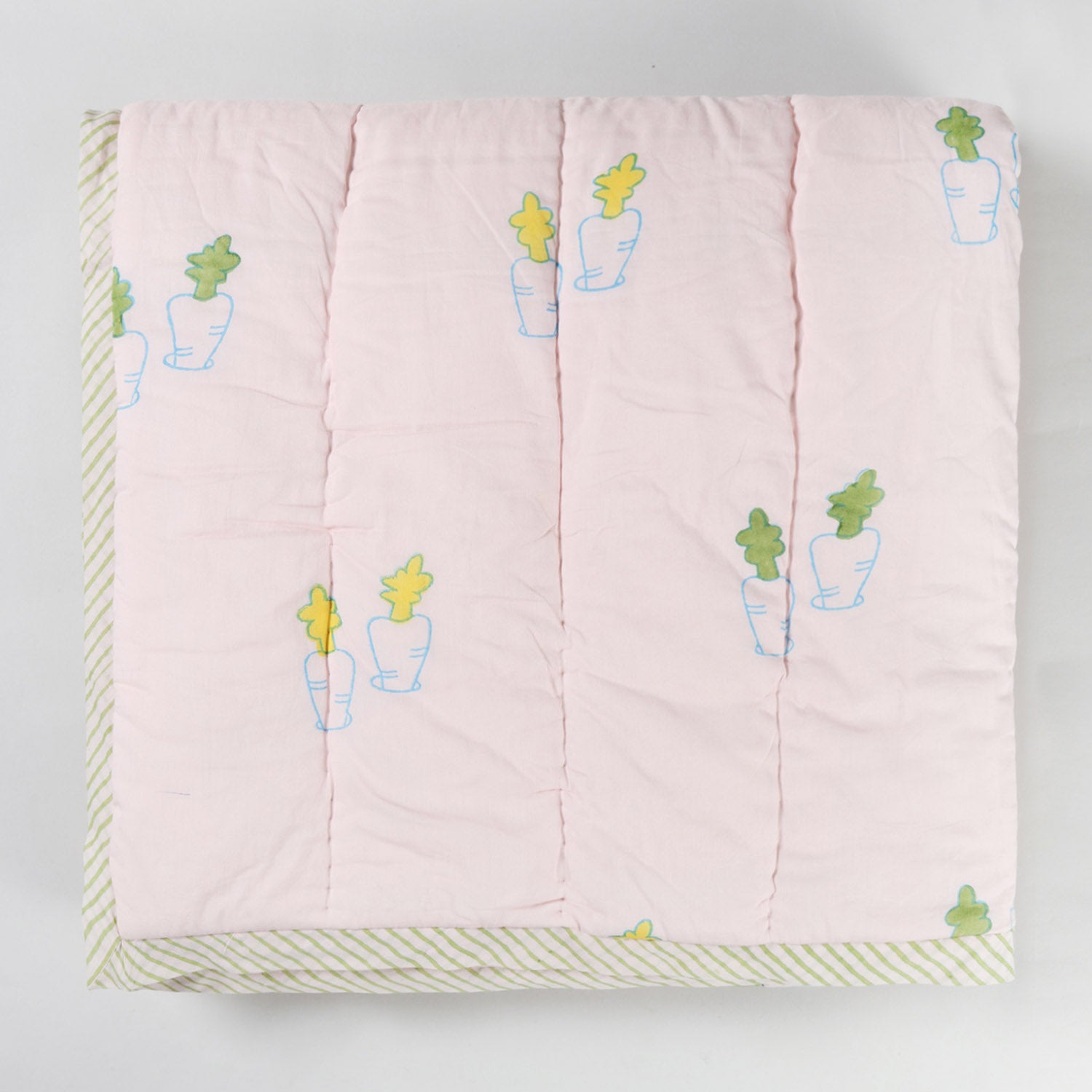  Folded hand block printed cotton quilt showcasing pastel bunny and carrot designs and soft breathable cotton fabric