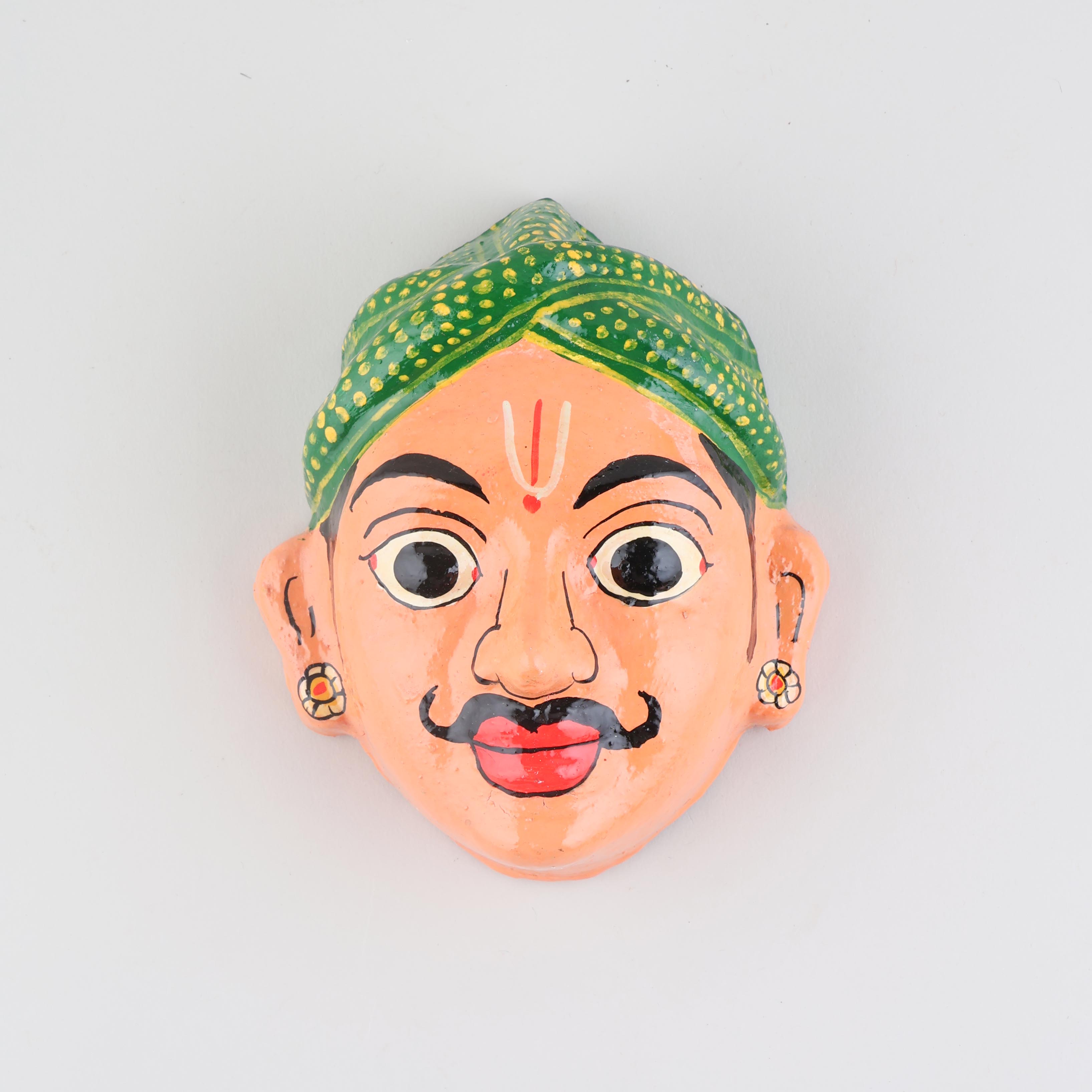 Hand-painted peach Cheriyal male mask crafted from papier-mache, showcasing traditional Telangana folk art details on a plain background