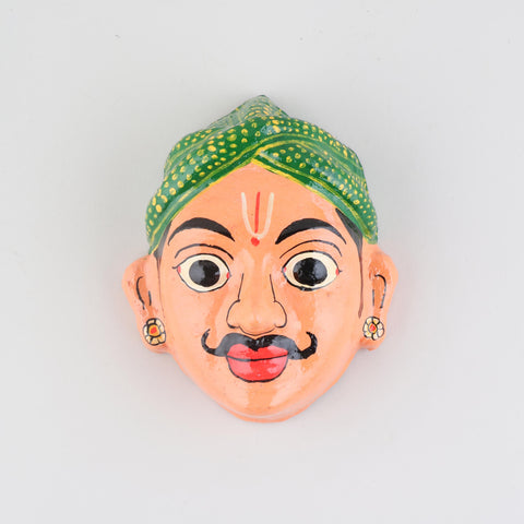 Hand-painted peach Cheriyal male mask crafted from papier-mache, showcasing traditional Telangana folk art details on a plain background