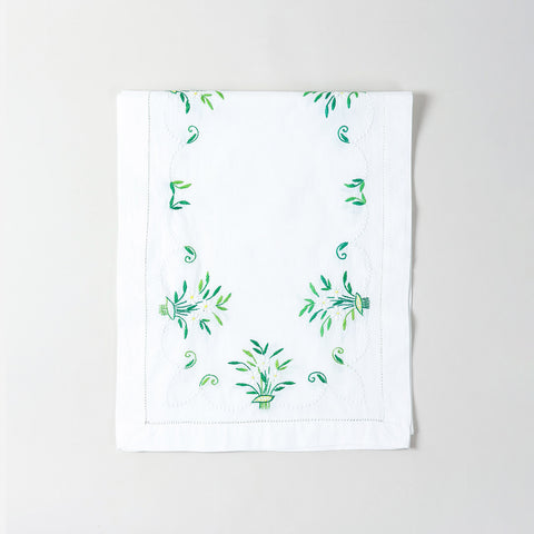 Folded white cotton table runner showcasing delicate periwinkle-inspired floral embroidery and handcrafted Bengal chikankari detailing