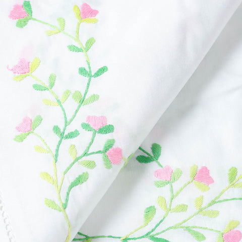 Close-up of pink blossom hand embroidery and delicate cutwork on a Bengal chikankari cotton tablecloth