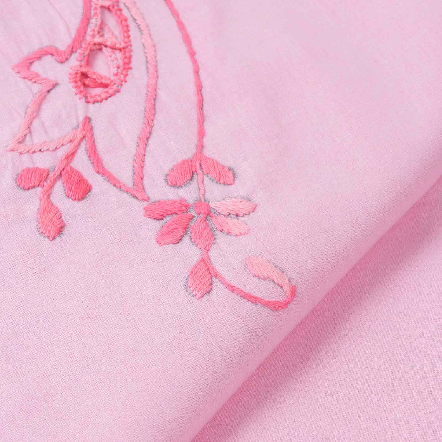 Close-up of dark pink chikankari hand embroidery on a pink cotton bedcover, highlighting artisan craftsmanship