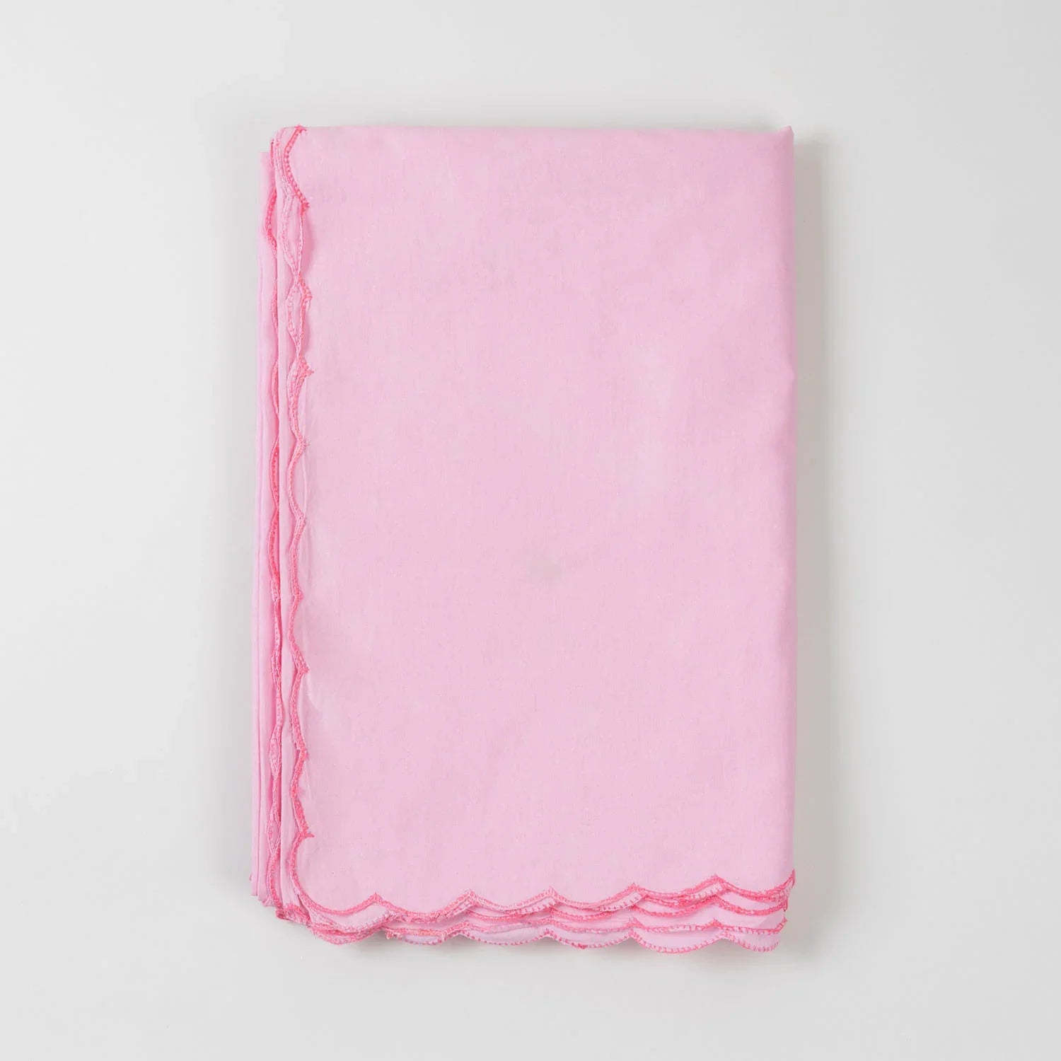 Folded pink cotton king-size bedcover showcasing soft fabric texture