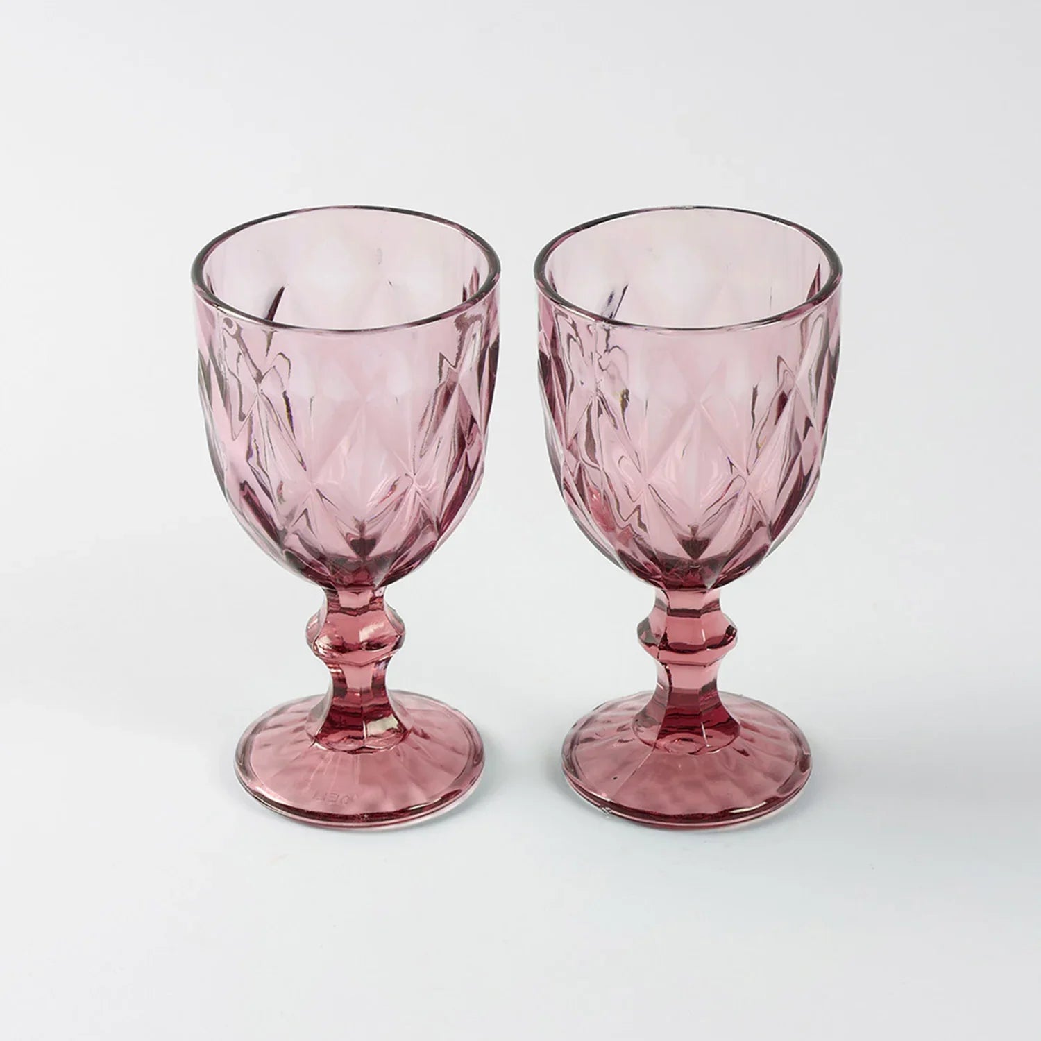 Front view of two pink diamond-pattern wine glasses placed side by side, showcasing handcrafted texture and elegant design