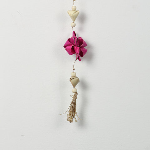 Close-up of pink folded paper star flowers on a decorative hanging