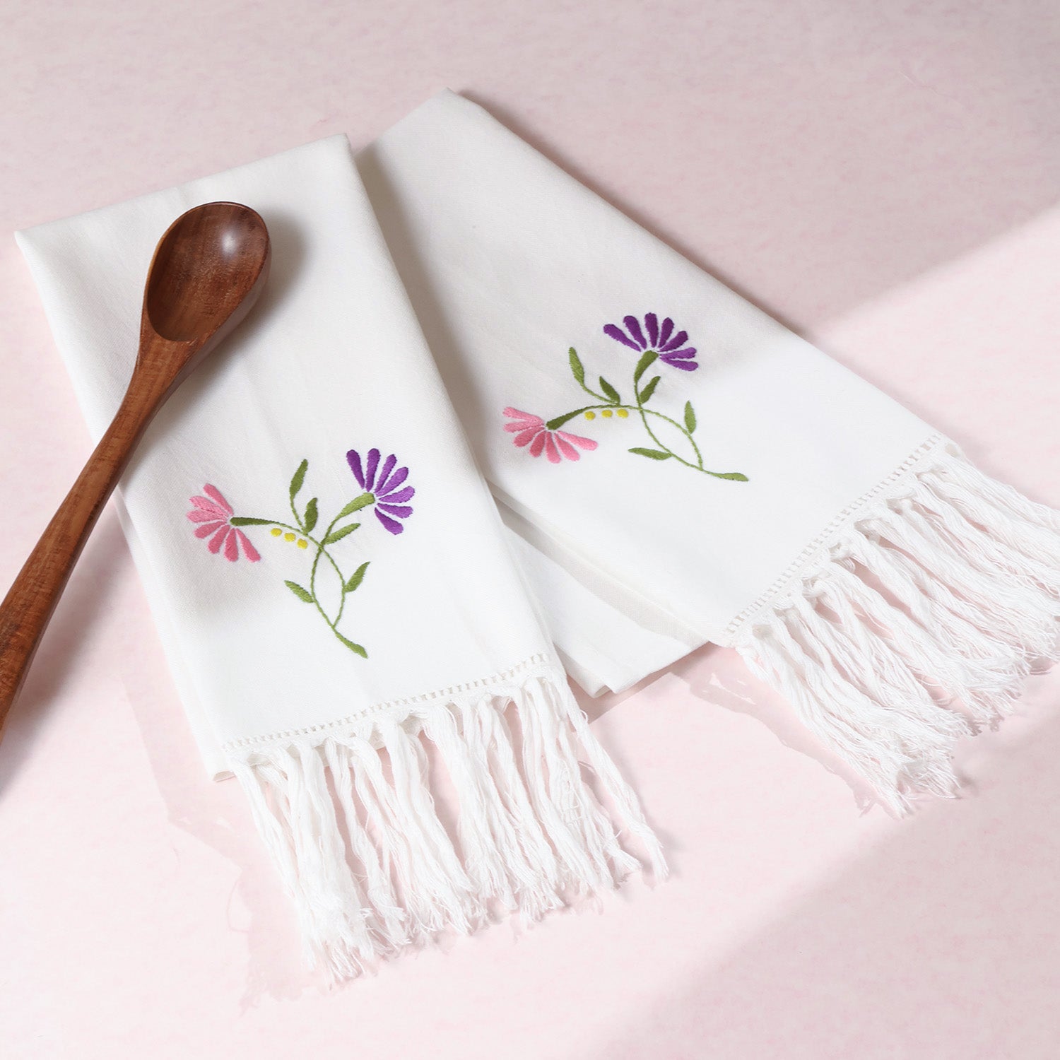 Pink and purple floral embroidered cotton kitchen towels styled with kitchen accessories for elegant kitchen linen decor
