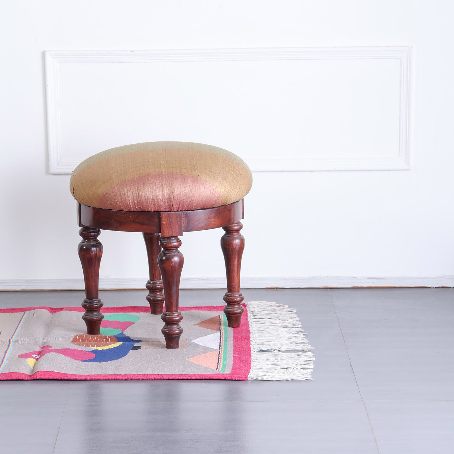 Pink handwoven cotton dhurrie with rabbit and peacock motifs styled in a hallway for a warm handcrafted look