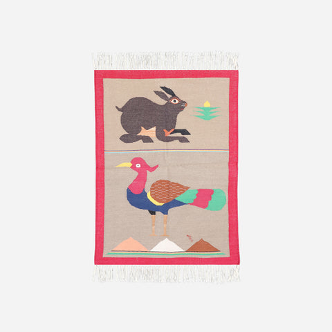Full-size 2x3 ft reversible cotton rug with rabbit and peacock designs on a soft pink woven base