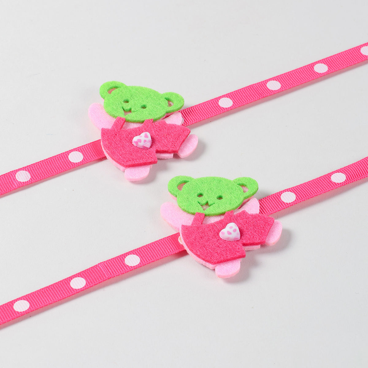 Close-up view of the handmade pink Teddy Bear Felt Kids Rakhi highlighting its soft felt design and colourful details.
