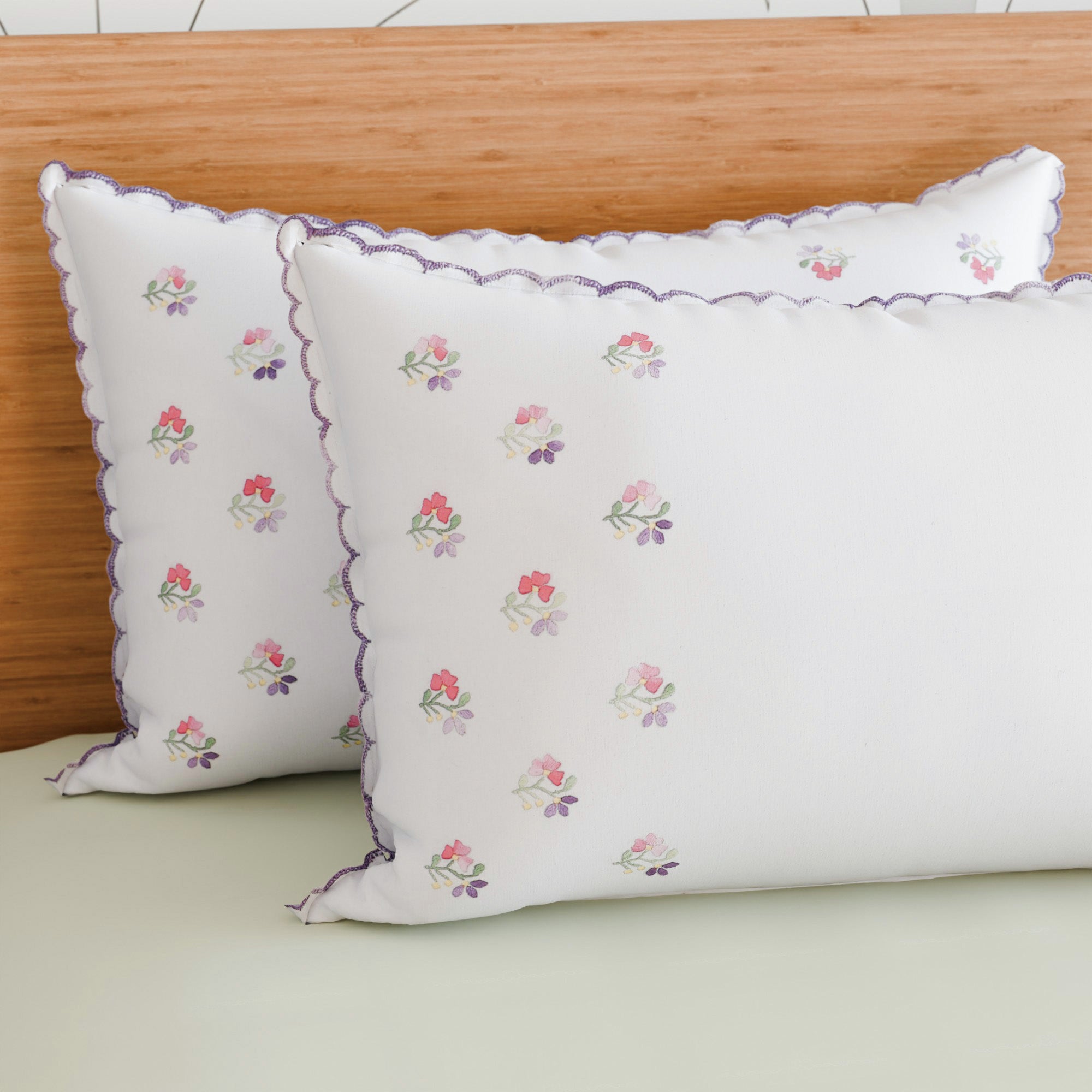 Purple chikankari embroidered pillow cases arranged on a bed for elegant bedroom decor and everyday comfort