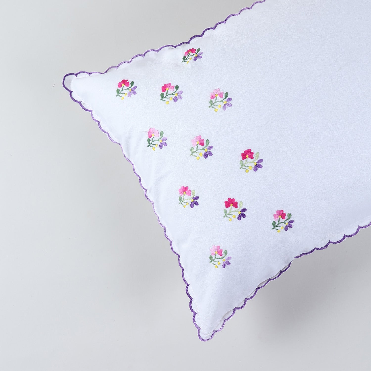 Detailed view of floral chikankari embroidery and purple scalloped edge on handcrafted pillow cover