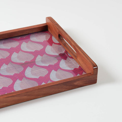 Corner angled view of handcrafted wooden tray showing purple fabric base with golden paisley pattern under glass top