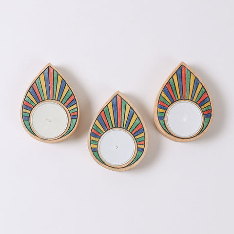 Three rainbow coloured wooden t-light holders displayed together as handcrafted home decor accents