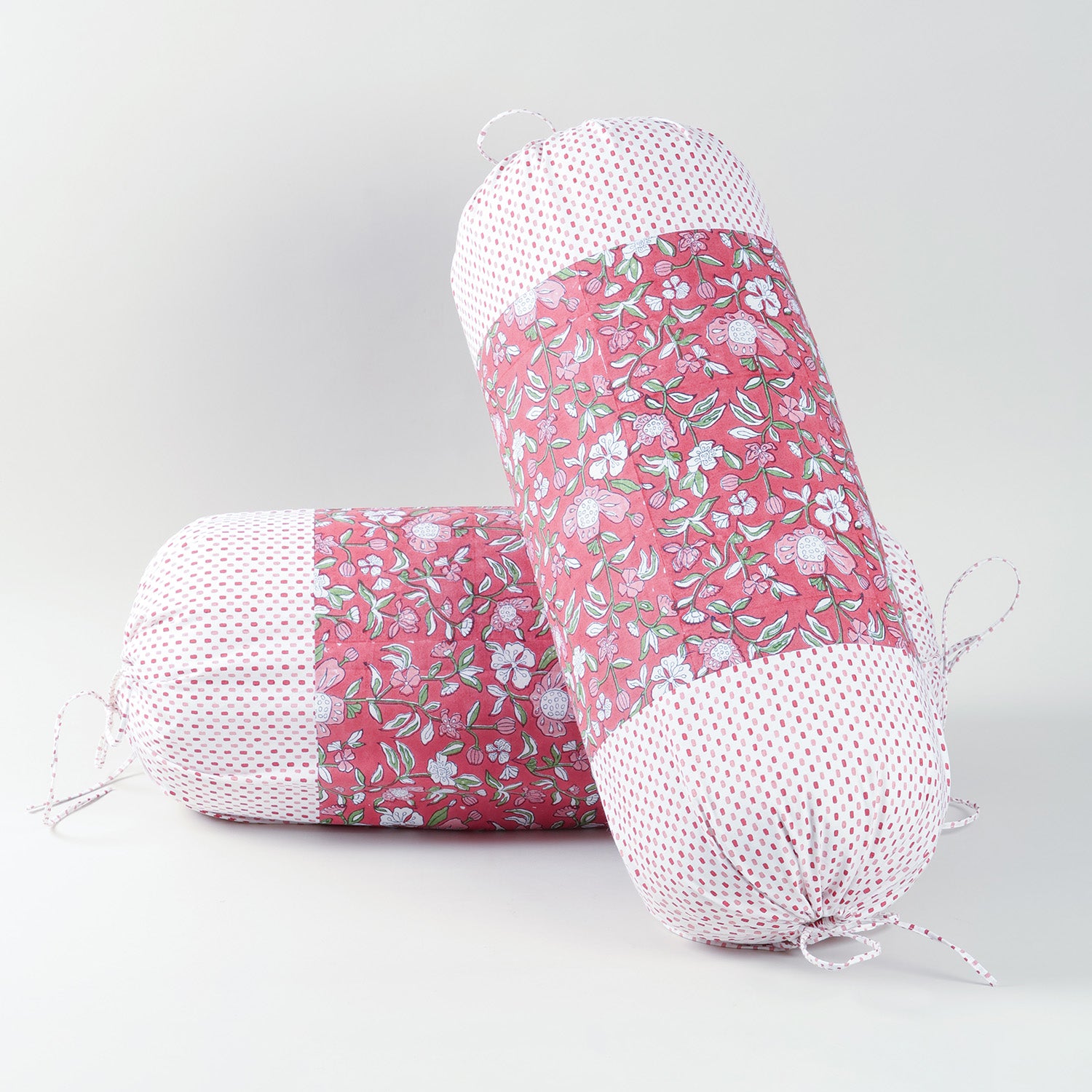 Set of two red hand block-printed cotton bolster covers featuring traditional patterns and artisanal craftsmanship