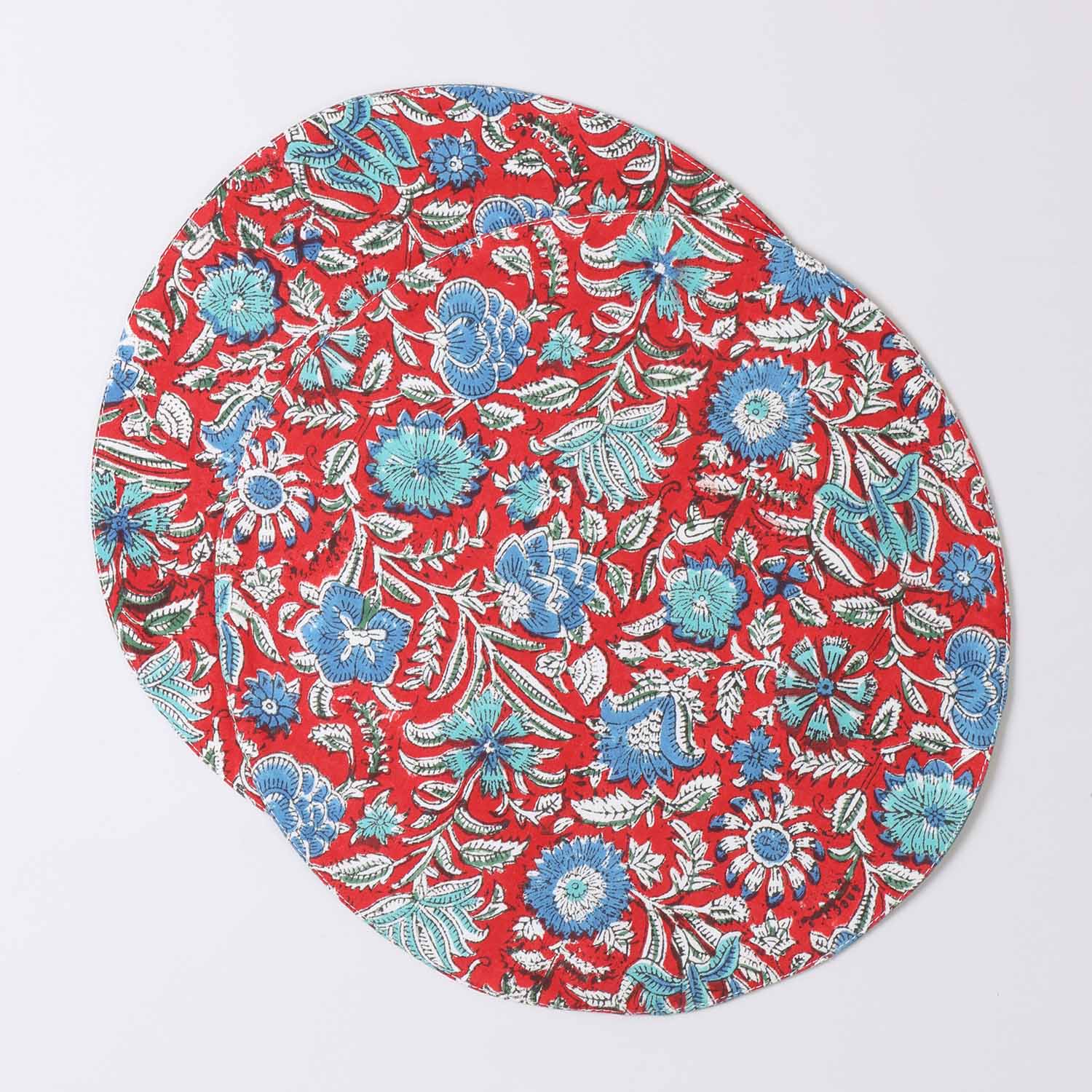 Set of 2 round cotton placemats featuring red and blue block printed designs displayed on a plain background