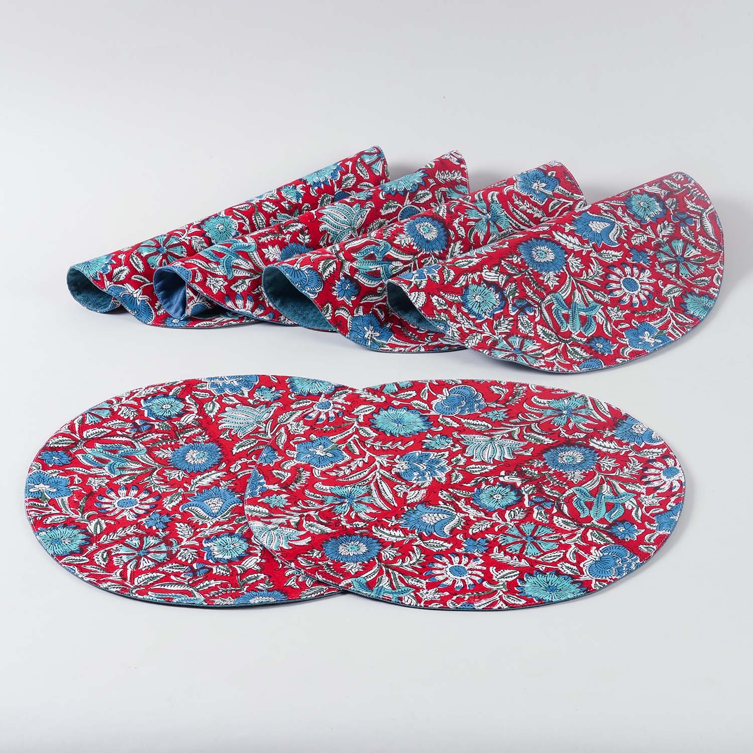 Six cotton placemats featuring traditional red and blue block printed patterns, handcrafted by Indian artisans for stylish table settings