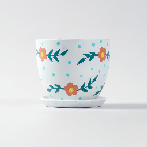 Red floral ceramic pot with plate shown at eye level with smooth cylindrical shape and painted floral motifs.
