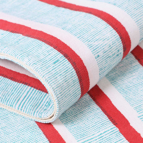 Detailed mid-section of a cotton table runner featuring red and green stripe block print motifs on a white background