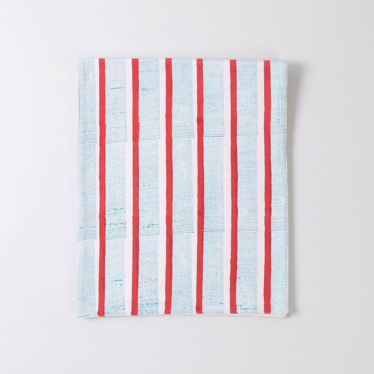 Folded cotton table runner featuring red and green stripe block printed patterns highlighting soft fabric and handcrafted detailing