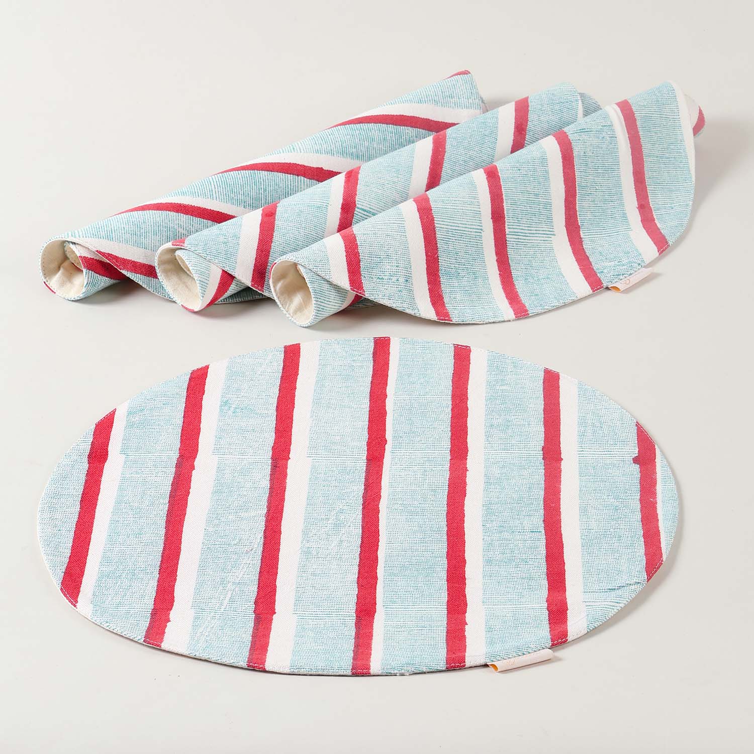 Set of four handmade cotton placemats with red and green stripe block print designs showcasing artisan craftsmanship and cotton table linen quality