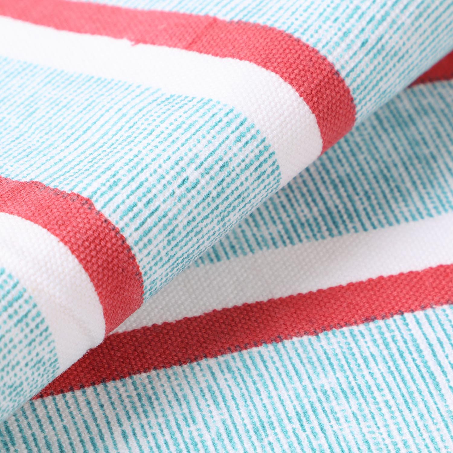 Detailed view of cotton placemat fabric with red and green stripe block print design, highlighting durable handcrafted construction