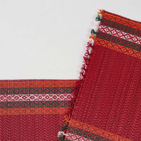 Close-up of a red Madhurkathi table runner featuring intricate handwoven patterns, natural fibre texture, and detailed border accents