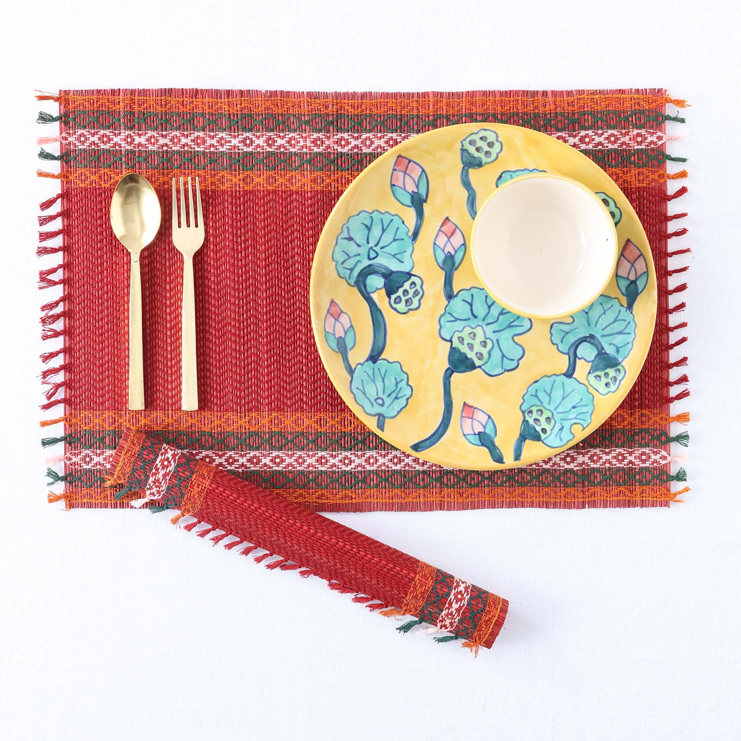 Handmade red Madurkathi placemats flat lay with sustainable dining accessories, highlighting eco-friendly woven table mats