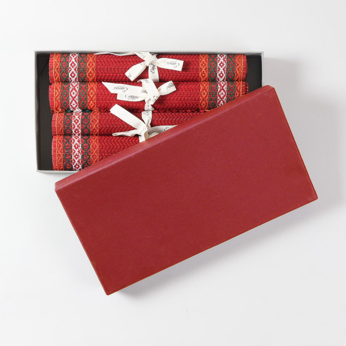 Handmade red Madurkathi table runner and placemat set packed in a gift box, featuring natural fibre weaving and colourful border detailing
