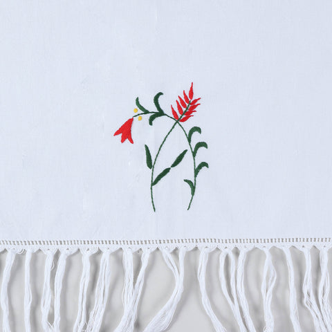 Close-up of red penstemon floral hand embroidery and textured tassel fringe on cotton kitchen towel