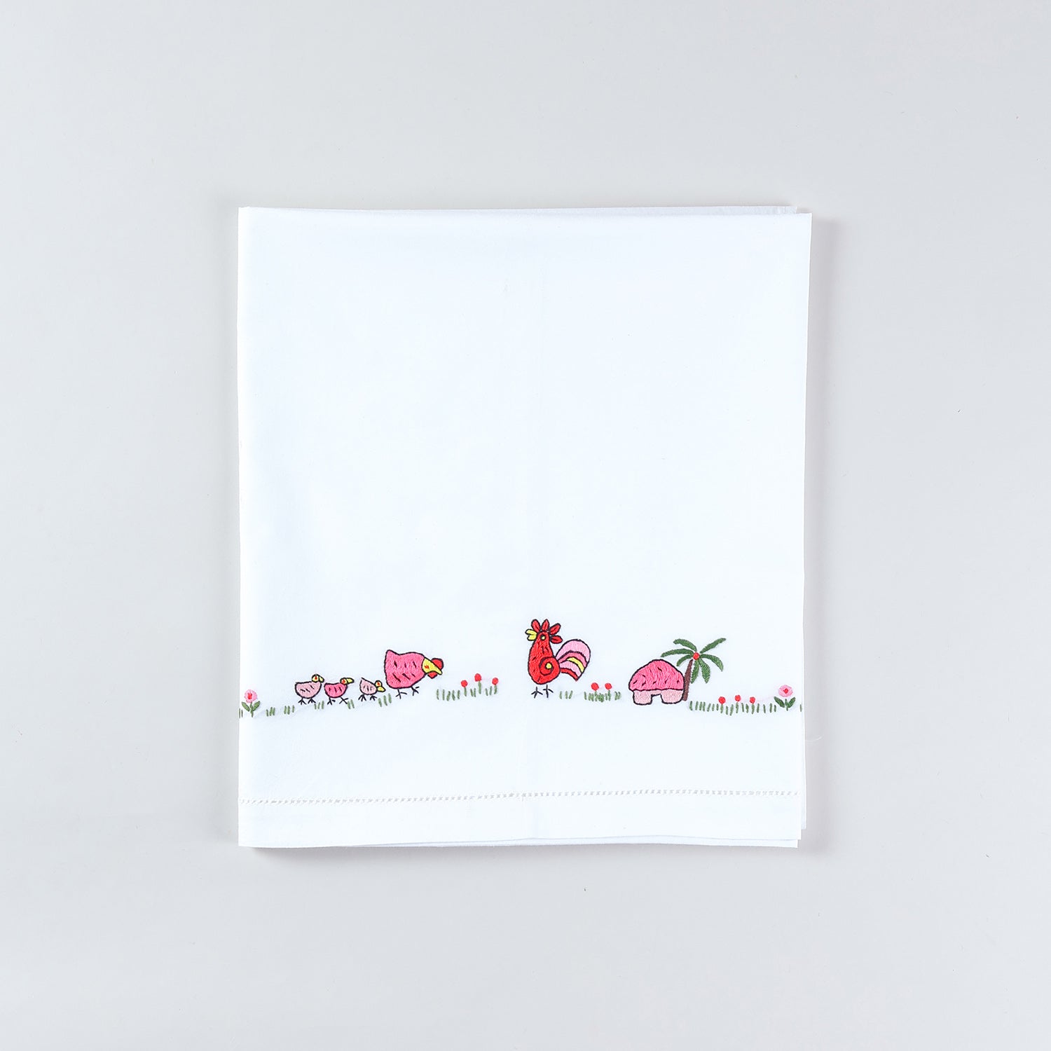 Folded cotton kids bedsheet and pillow cover set featuring colourful rooster and hen  hand embroidery on a white cotton base