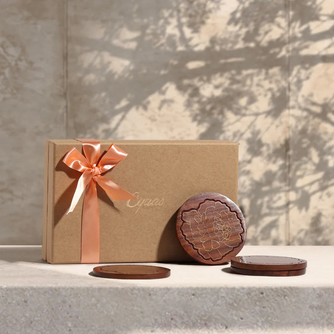 Rosewood coaster gift set with marigold floral brass inlay, beautifully styled as a festive gift with elegant packaging