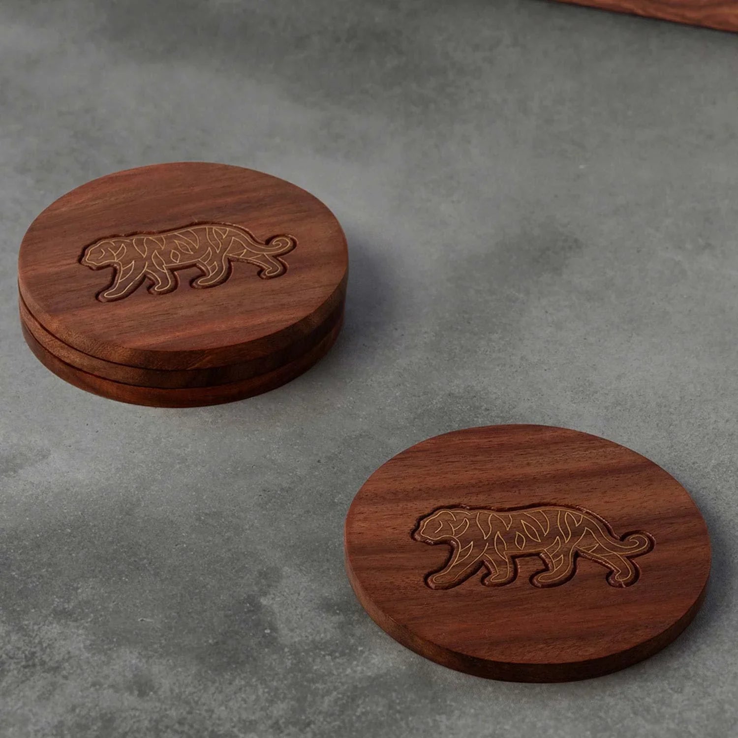 Rosewood coaster set with tiger brass inlay, styled on a table top, making an elegant corporate gift