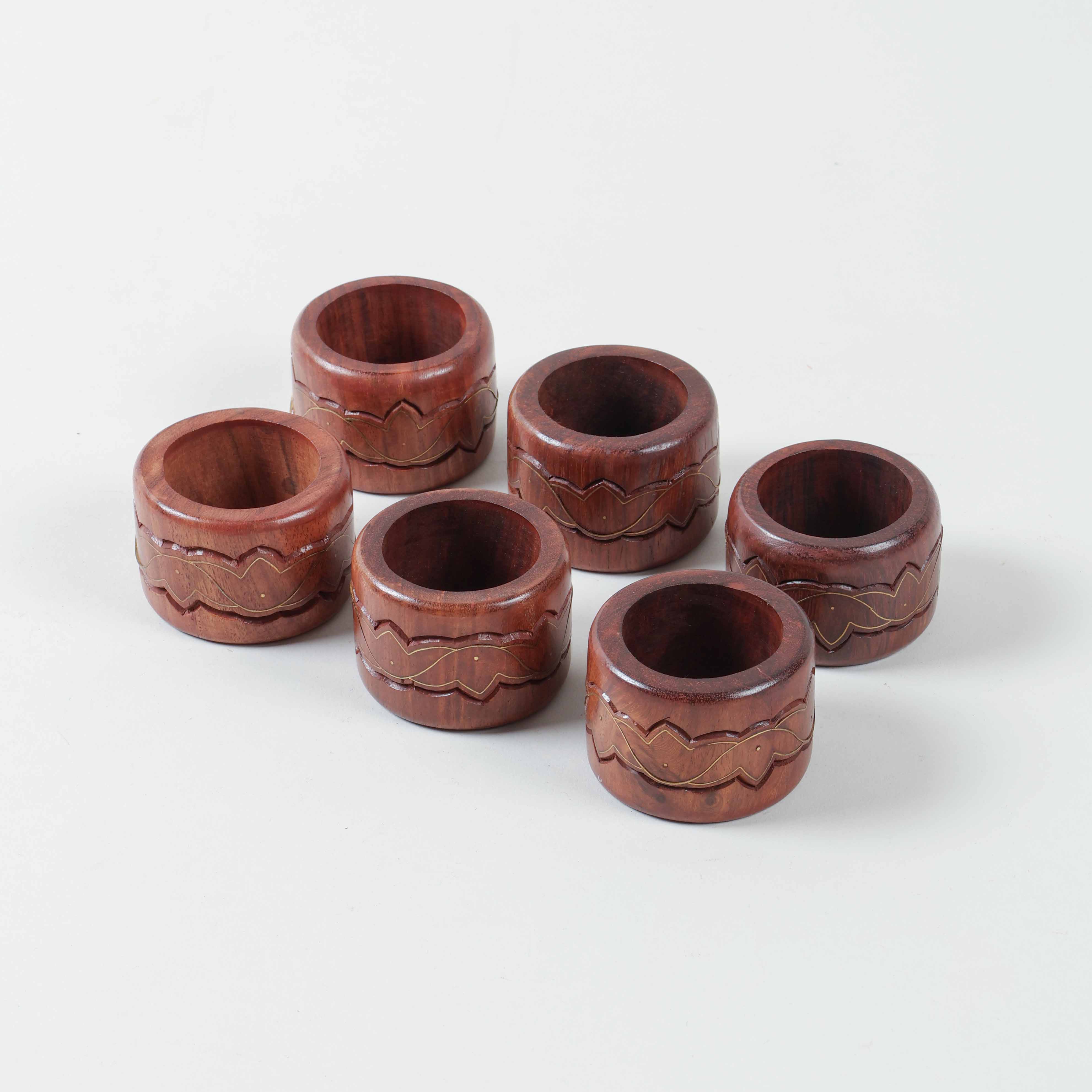 Set of six round wooden napkin rings featuring lotus inspired brass inlay and handcrafted detailing
