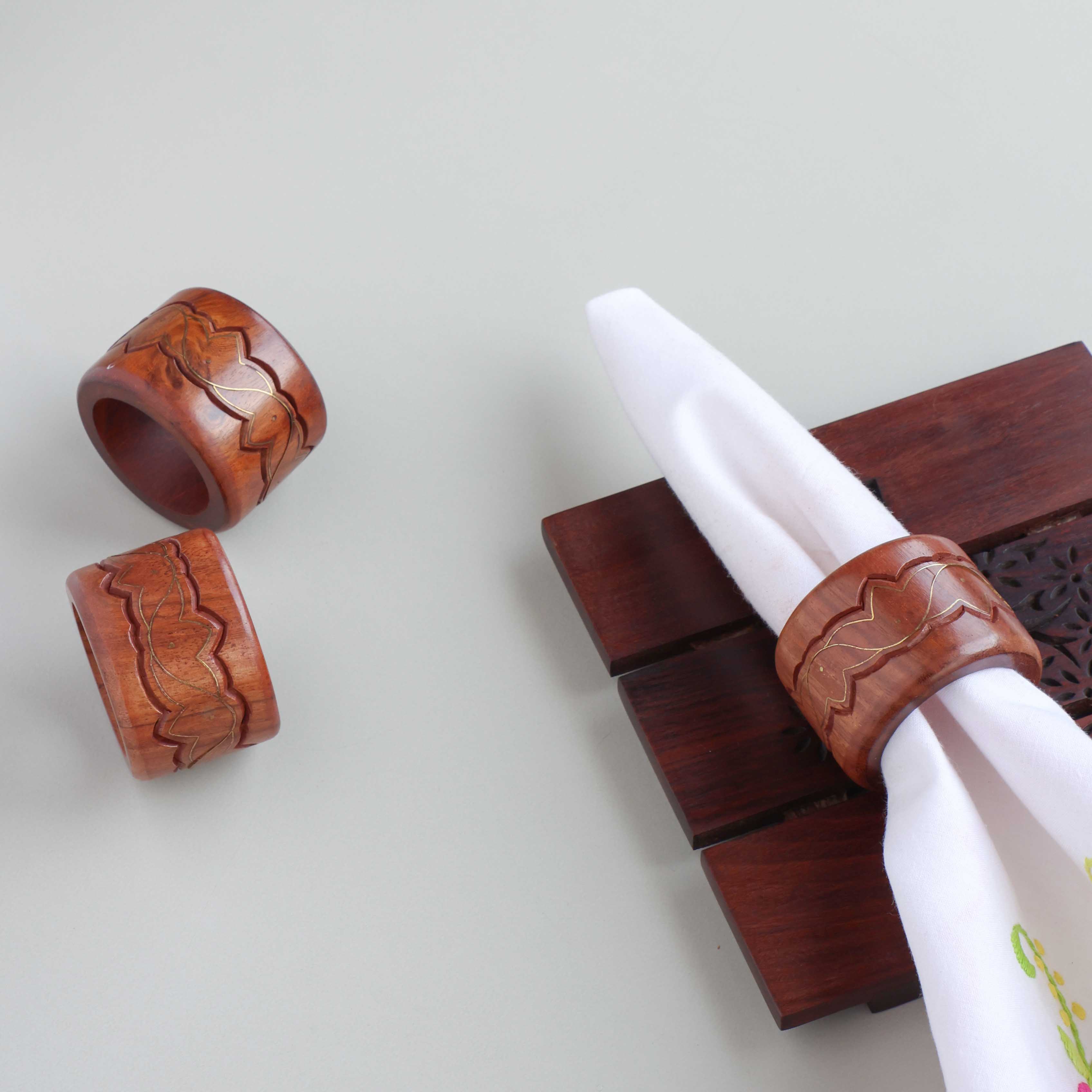 Round wooden napkin rings with lotus brass inlay styled on a dining table for elegant table setting decor