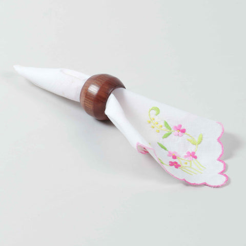 Handcrafted round wooden napkin ring holding a folded table napkin for refined dining table styling