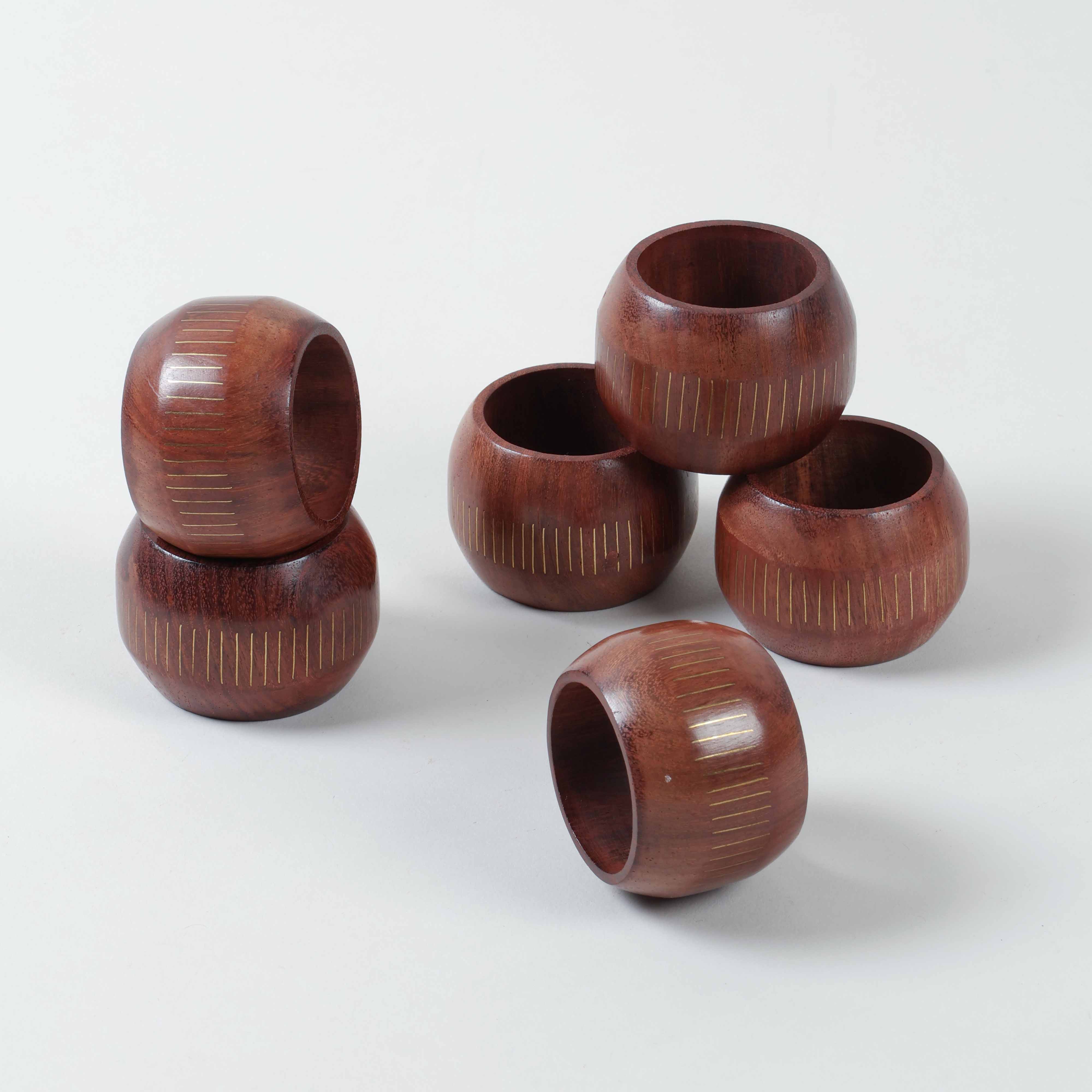Stacked set of six round wooden napkin rings featuring railroad inspired brass inlay and handcrafted detailing