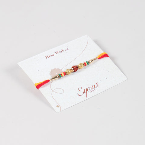 Angled view of the Handmade Rudraksha & Metal Bead Rakhi attached to a Best Wishes greeting card for Raksha Bandhan gifting.