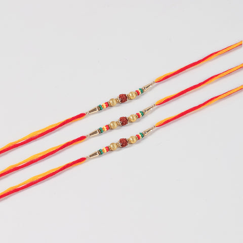 Close-up of the Handmade Rudraksha & Metal Bead Rakhi featuring natural Rudraksha, gold-toned metal beads, colourful spacers and Mauli thread.