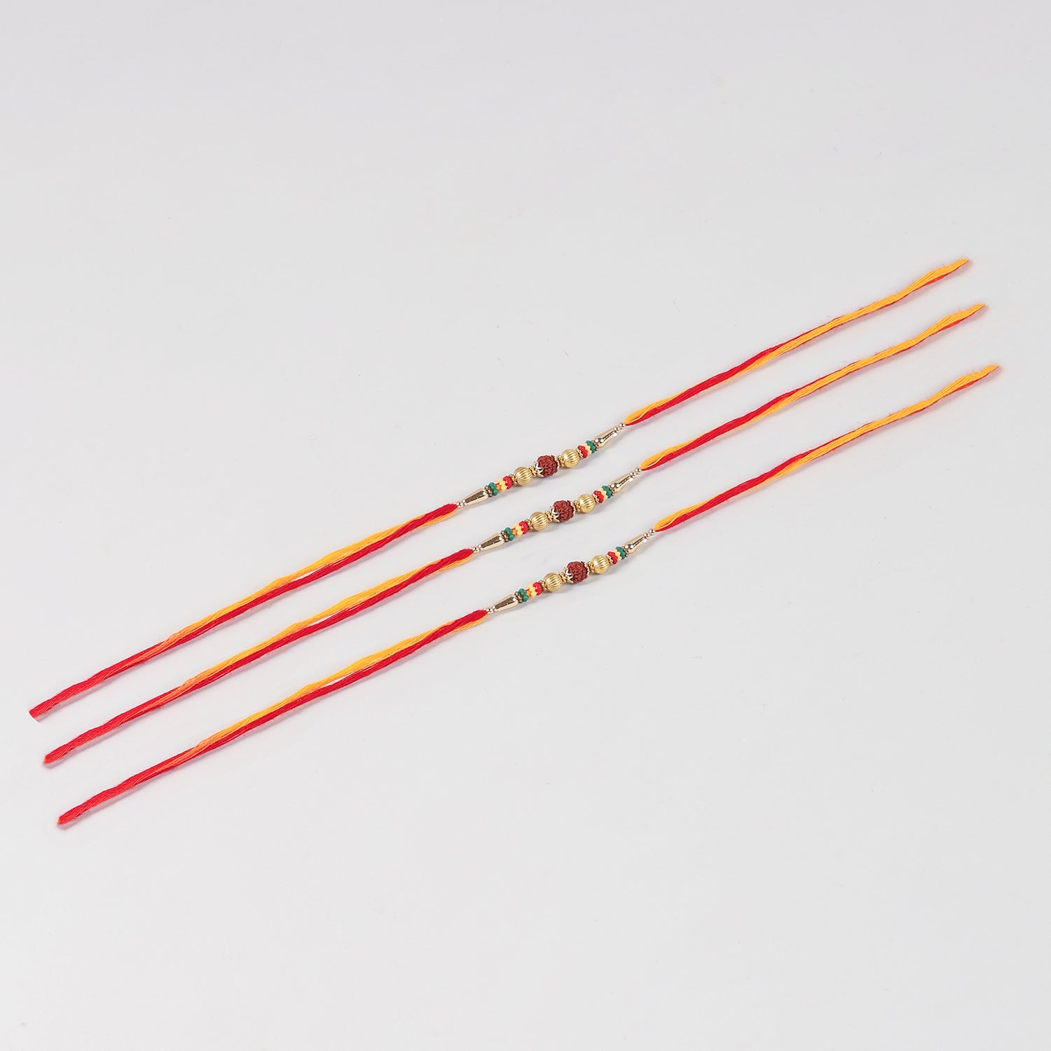 Full-length view of the Handmade Rudraksha & Metal Bead Rakhi Set of 3 showing handcrafted beadwork and traditional Mauli thread