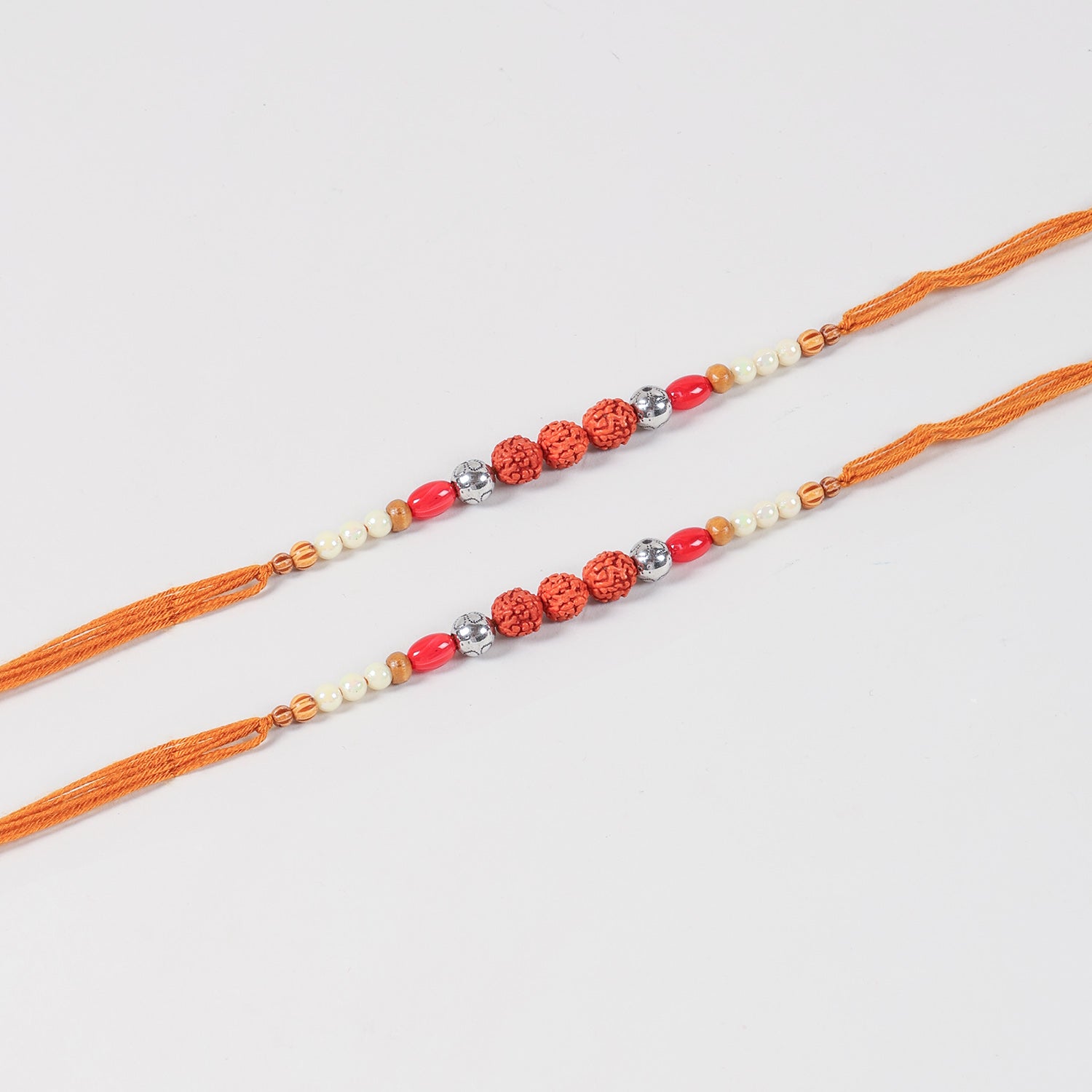 Close-up of the Handmade Rudraksha & Bead Rakhi featuring natural Rudraksha, faux pearls, red beads, decorative glass and wooden beads, and antique-finish metal spacers
