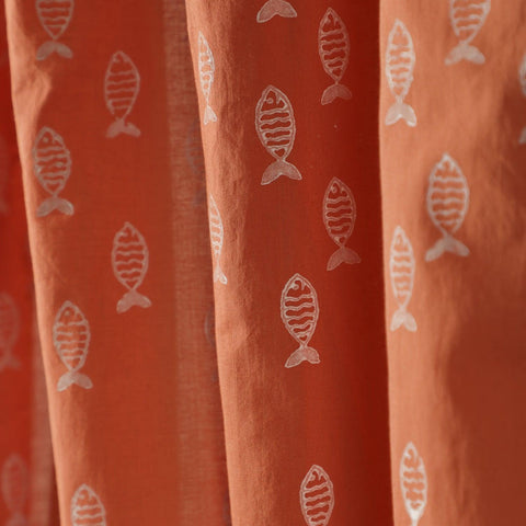 Close-up of the hand block printed fish pattern on soft rust mulmul cotton curtain fabric