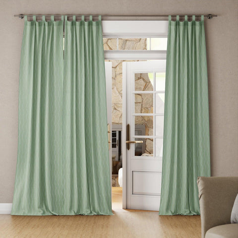 Living room with a sage green mulmul cotton wave block print curtain hanging in a door with soft natural light