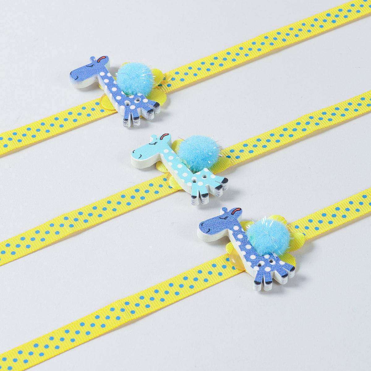 Close-up of the handmade Set of 3 Giraffe Wooden Kids Rakhi with yellow ribbon and giraffe design.