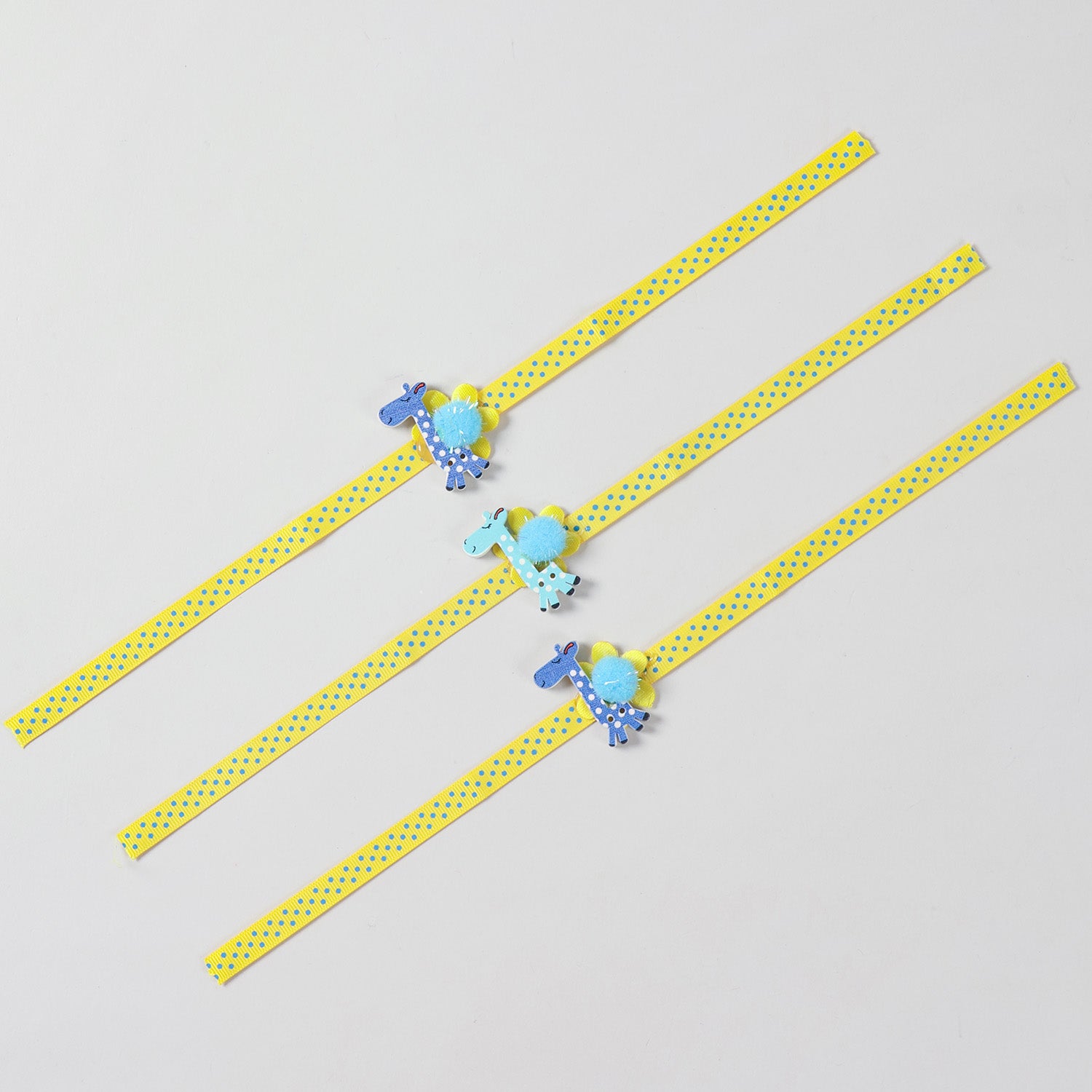 Full-length view of the set of 3 Giraffe Wooden Kids Rakhi showing the complete yellow ribbon and handcrafted details