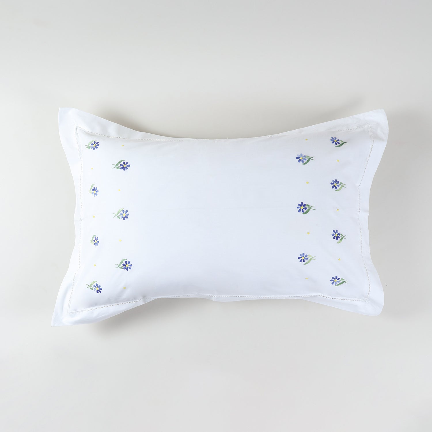 White cotton pillow case decorated with Forget-me-not flower embroidery in lavender and green tones
