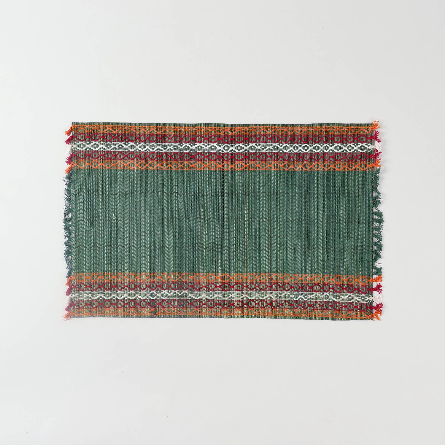 Full view of a handmade green Madurkathi placemat on a plain background, showcasing natural river grass weaving and colourful border detailing