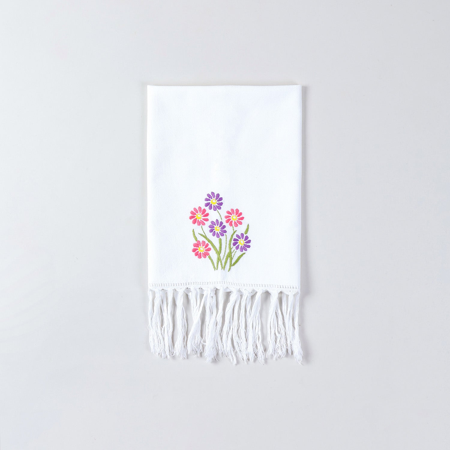 White cotton kitchen towel decorated with pink and purple daisy embroidery inspired by Bengal chikankari art