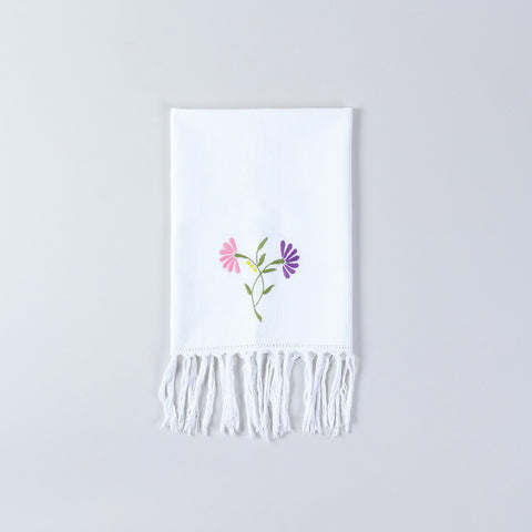 White cotton kitchen towel decorated with pink and purple floral embroidery and handcrafted detailing
