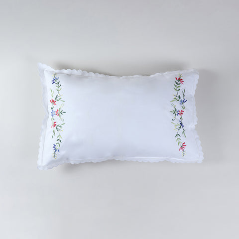 White cotton pillow case decorated with colourful wild flower embroidery inspired by nature
