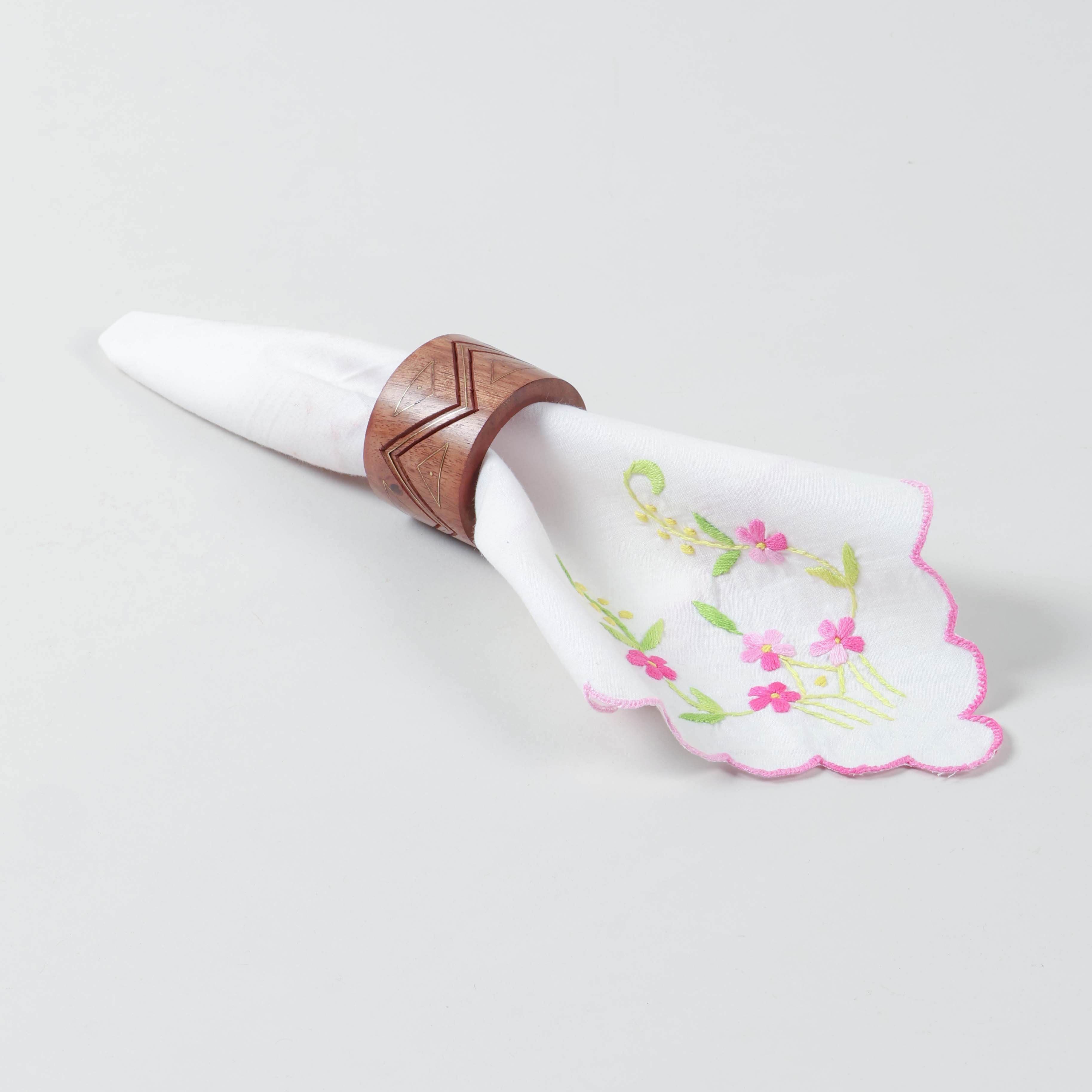 Single wooden napkin ring with brass inlay holding a table napkin in an elegant dining table setting